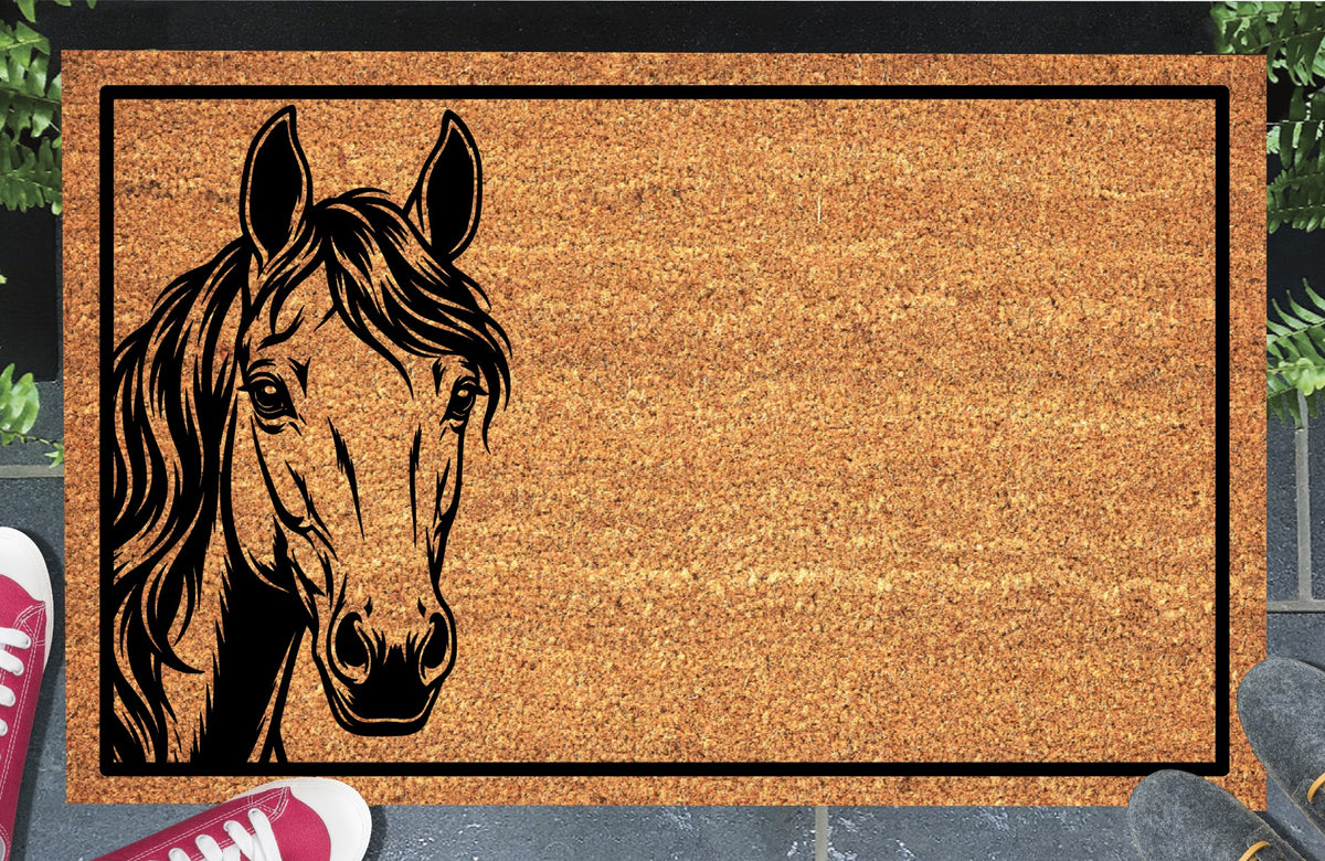 Morgan Horse peeking from the left edge of a natural coir doormat, with upright ears, expressive eyes, a long wavy mane and black border, shown at an entryway.