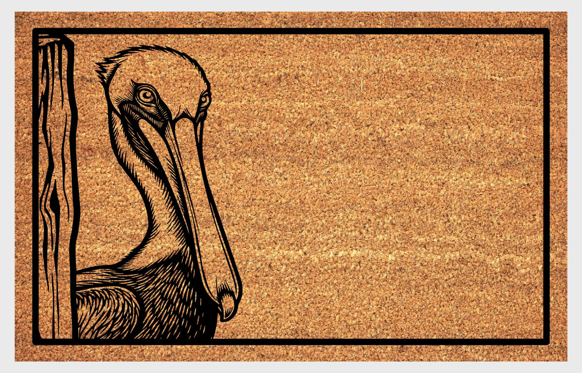 Close-up of a natural coir doormat featuring a long-billed Pelican peeking from the left edge beside a wood-grain post.