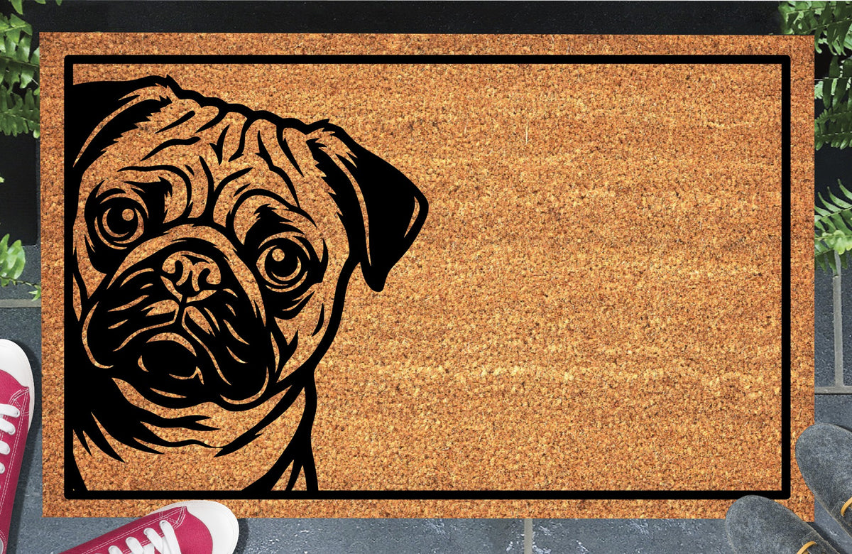 Pug peeking from the left edge of a natural coir doormat with a black rectangular border, shown at an entryway.