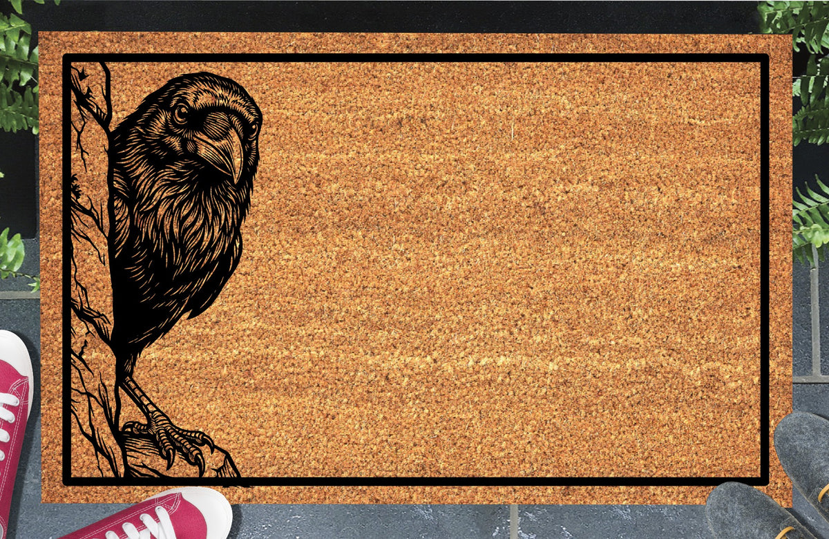 Raven peeking around a tree trunk on a natural coir doormat with a black border, displayed on a paved doorstep.