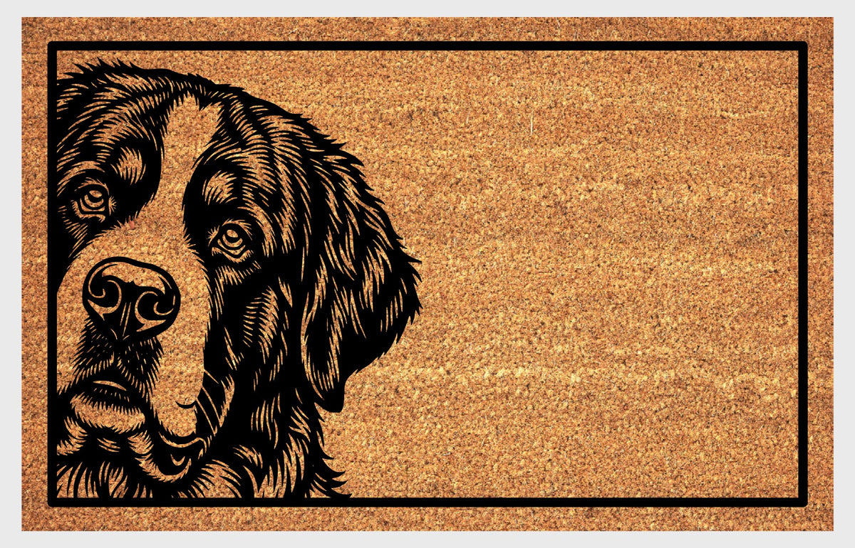 St. Bernard peeking design on natural coir, showing expressive eyes, drooping ears and a broad muzzle within a black rectangular border.
