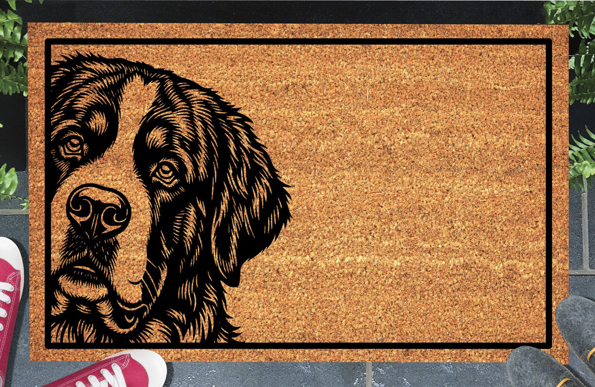 Saint Bernard doormat with expressive eyes, drooping ears and a broad muzzle inside a black border, displayed on a paved doorstep.
