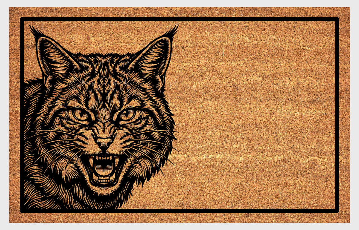 Scottish Wildcat coir doormat flat lay — mid-hiss Scottish Wildcat portrait peeking up from the bottom left edge of the mat on natural coir