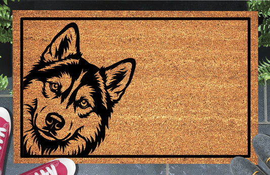 Siberian Husky doormat with a tilted head, upright ears and distinctive facial markings inside a black border, displayed on a paved doorstep.
