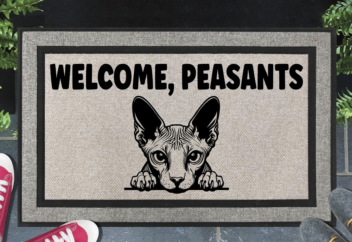 Sphynx cat Welcome Peasants all-weather doormat flat lay — hairless cat peering over the bottom edge beneath bold Welcome Peasants text