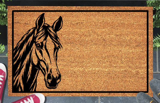 Thoroughbred Horse peeking from the left edge of a natural coir doormat, with upright ears, a flowing mane and black rectangular border, shown at a doorstep.
